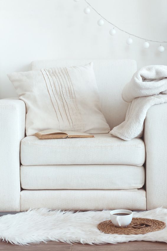 a white couch with pillows and blankets on it