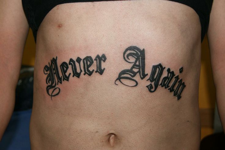 a woman's stomach with the words never again tattooed on her side, in cursive font