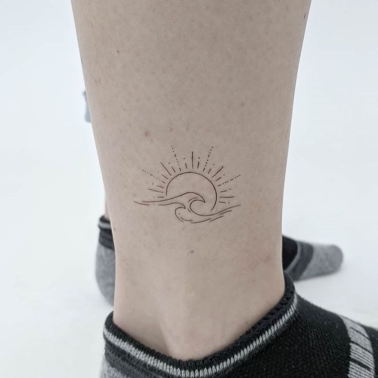 a person's foot with a small tattoo on the side of their leg,