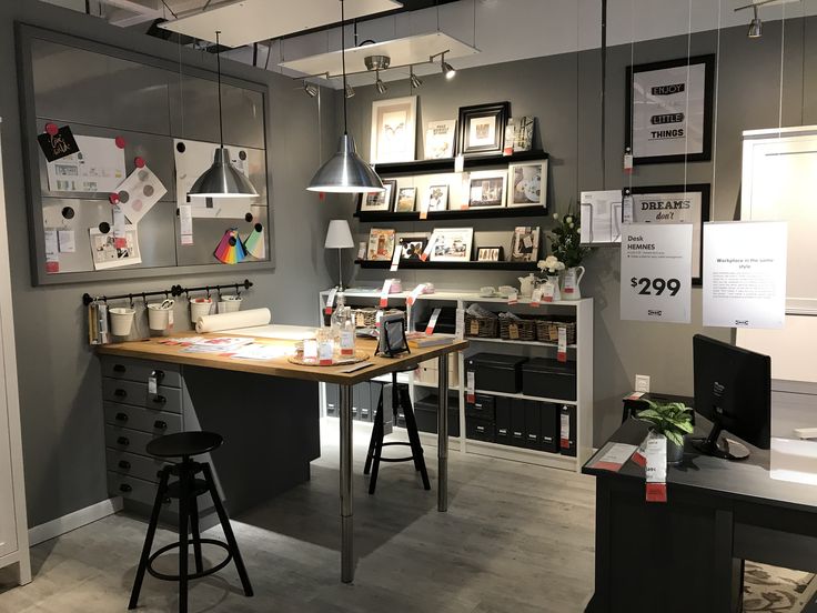 an office with two desks and several pictures on the wall