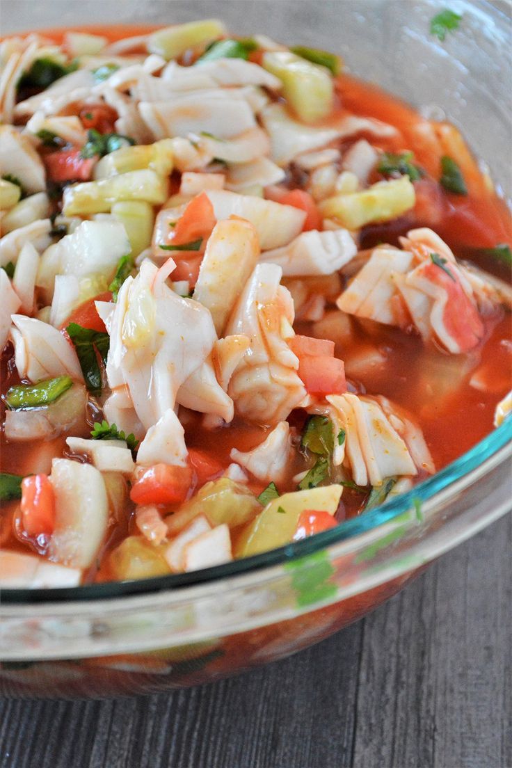 a glass bowl filled with pasta and vegetables