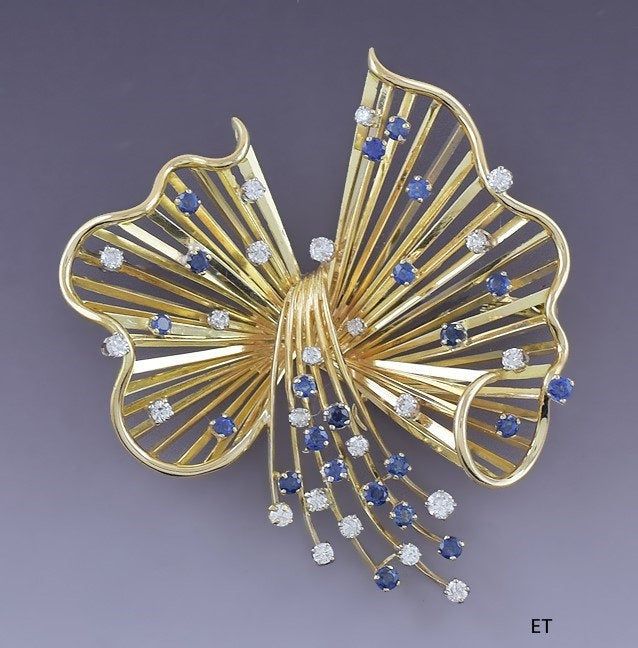 a gold brooch with blue and white stones