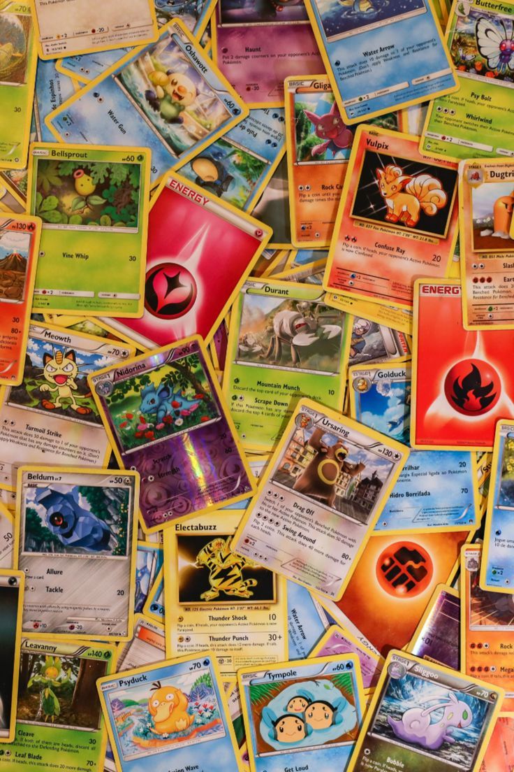 many pokemon cards are spread out on the table