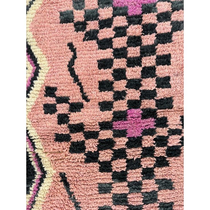 a pink rug with black and white designs on it