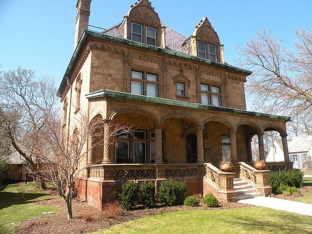 an old brick house with a green roof