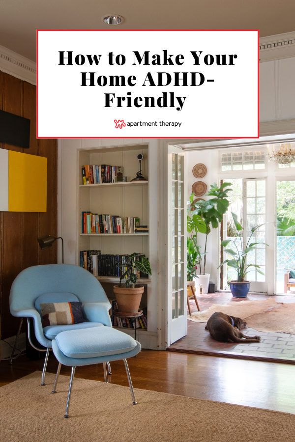 a blue chair sitting on top of a hard wood floor next to a book shelf