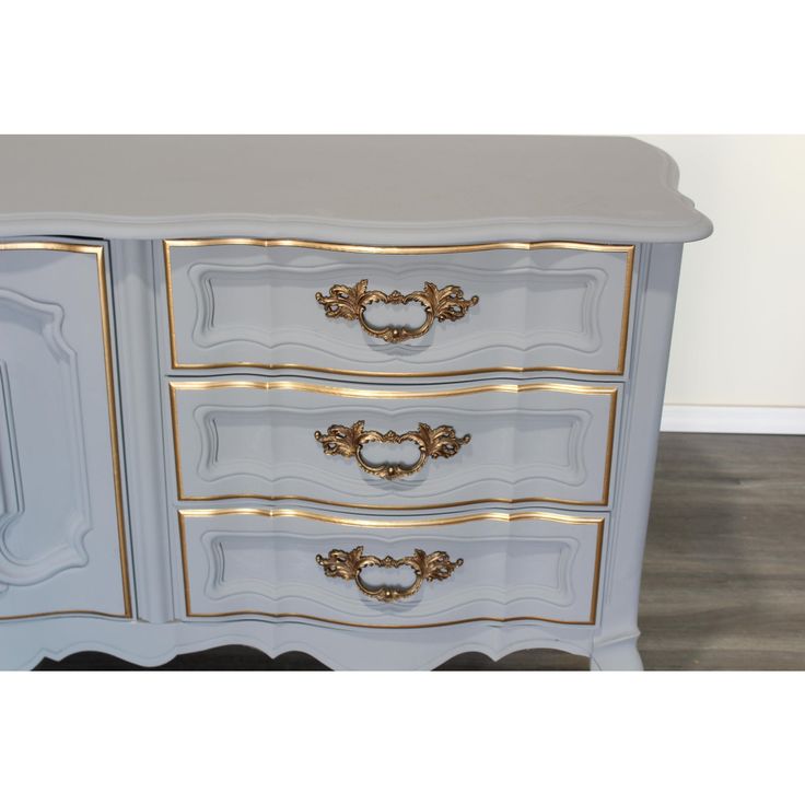 a white and gold dresser with drawers