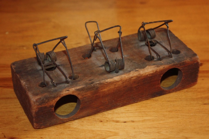 a wooden box with four metal mice in it