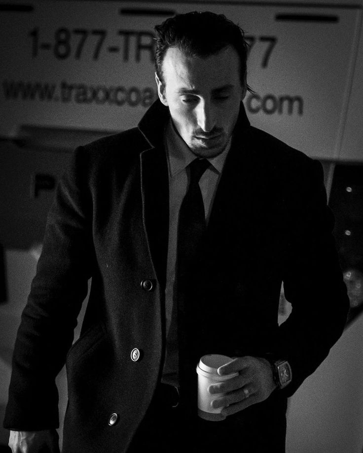 a man in a suit and tie holding a coffee cup