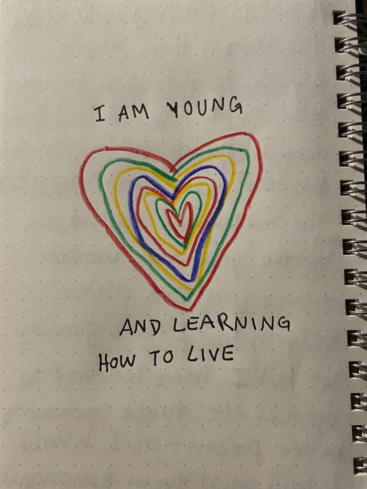 i am young and learning how to live written on a spiral notebook with colored hearts