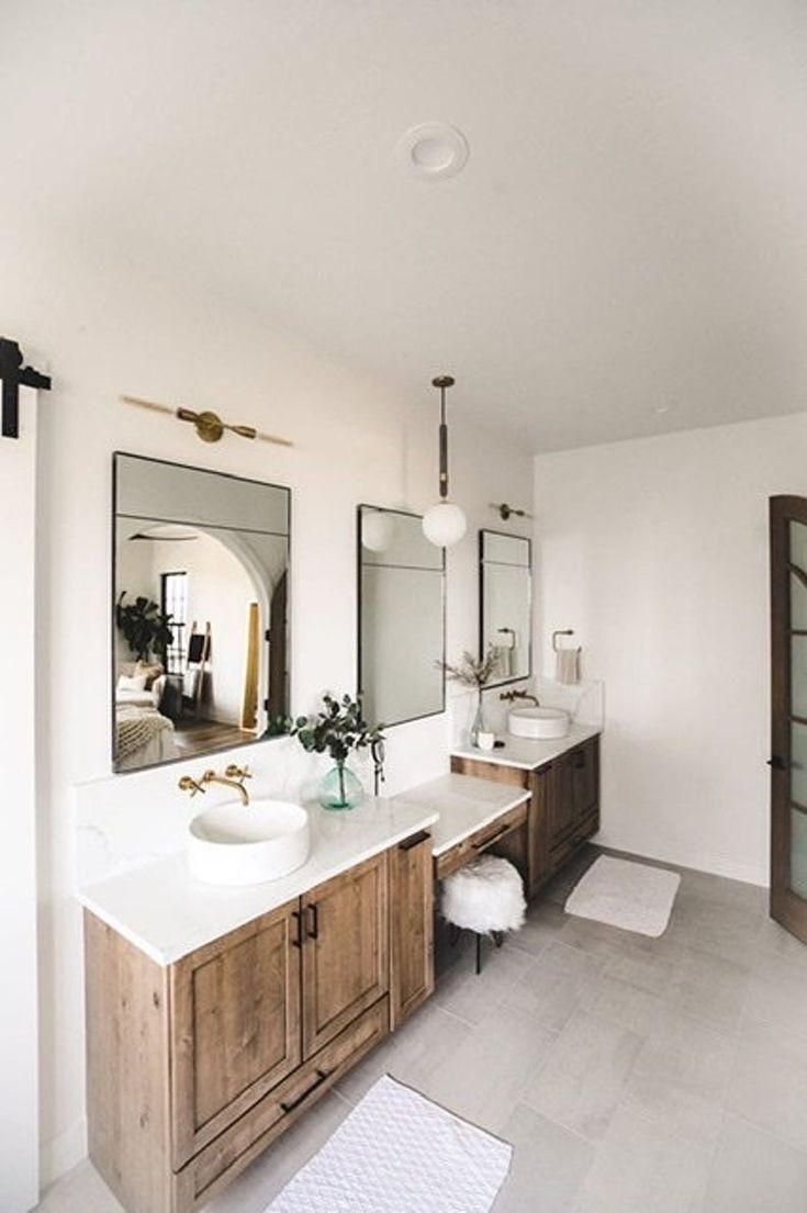 a large bathroom with two sinks and mirrors