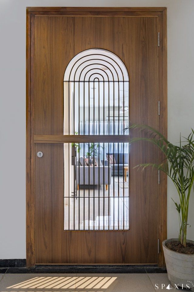 a wooden door with bars on it and a potted plant