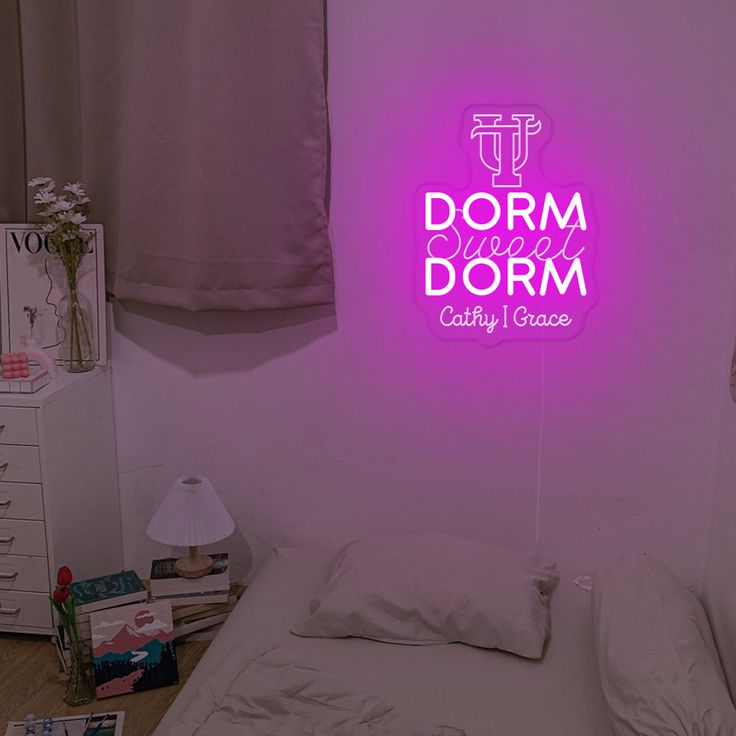 a bed room with a neatly made bed and a neon sign above it that reads dorm dorm