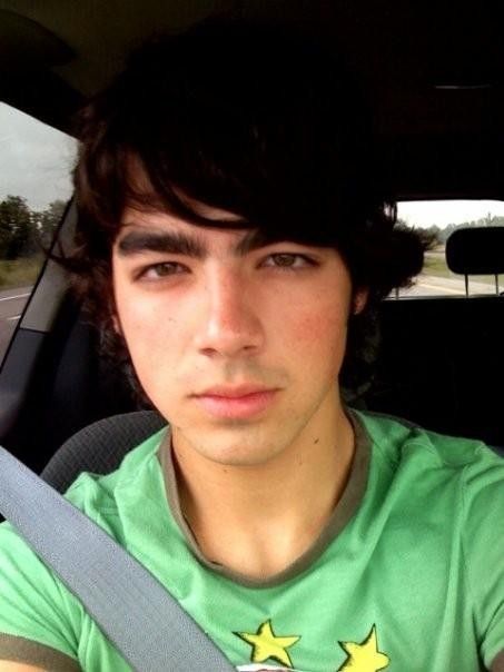 a young man sitting in the back seat of a car