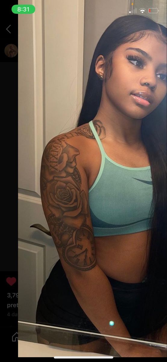 a woman with long black hair and tattoos on her arm is taking a selfie