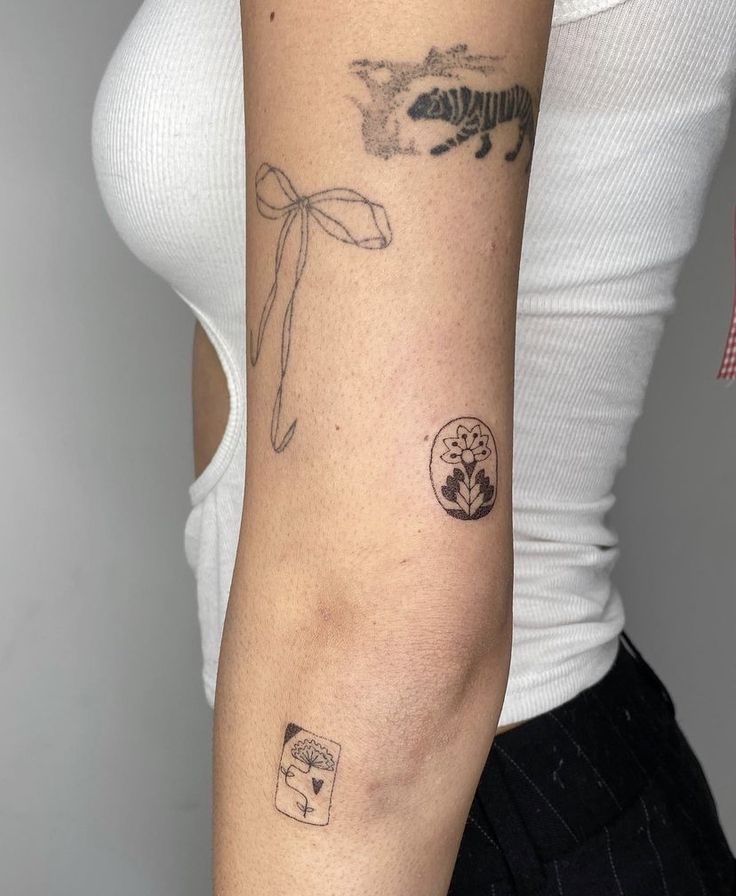 a woman's arm with tattoos on it, including an insect and flower tattoo