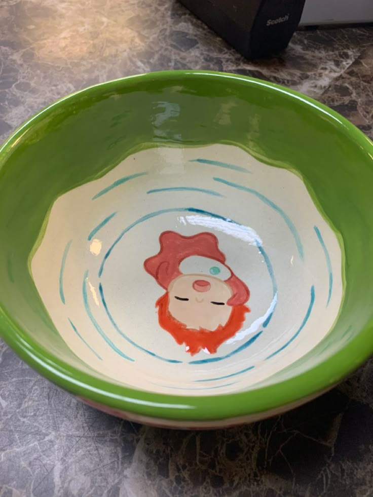 a green bowl with a cartoon character painted on it