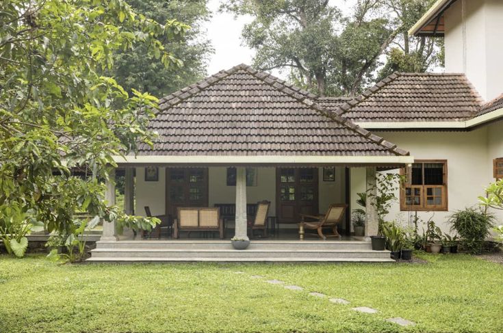 a white house sitting on top of a lush green field