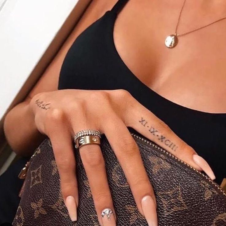 a woman with two rings on her finger and one ring on her hand, holding a brown louis vuitton purse