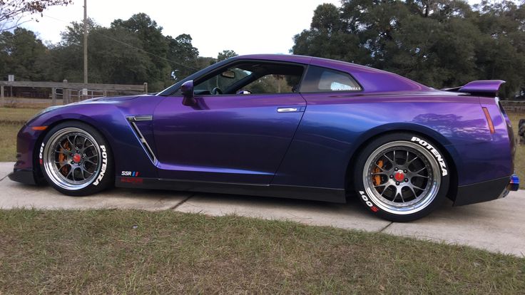 the purple sports car is parked on the side of the road