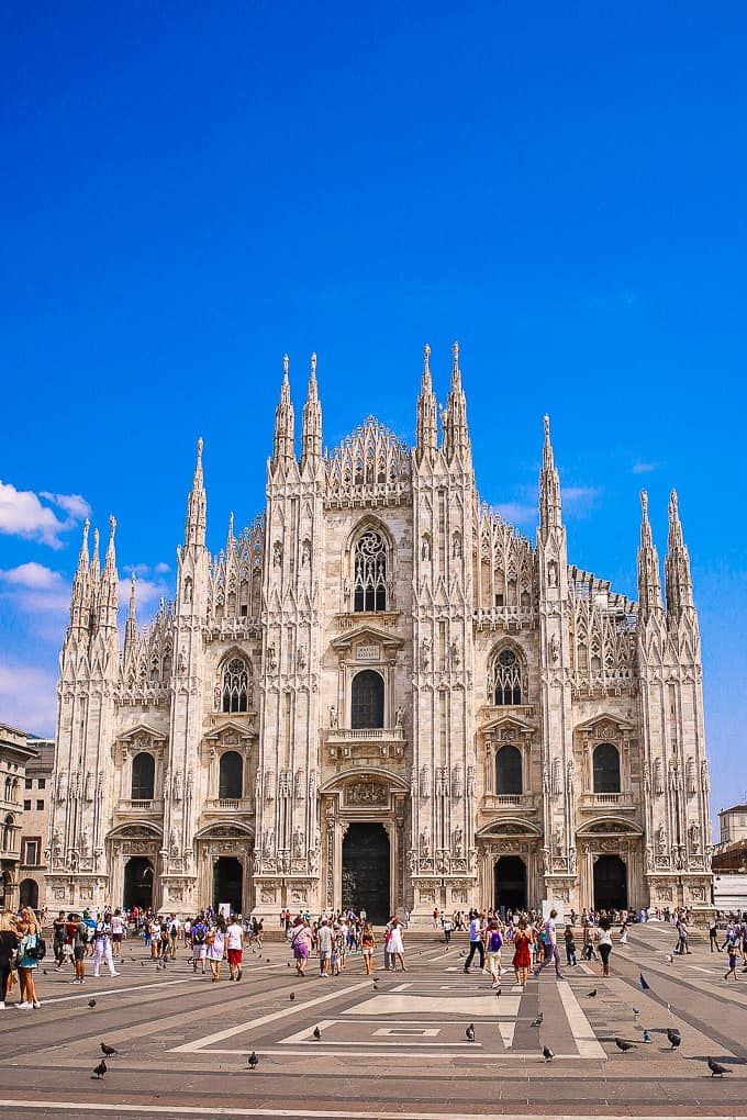 people are walking around in front of the cathedral