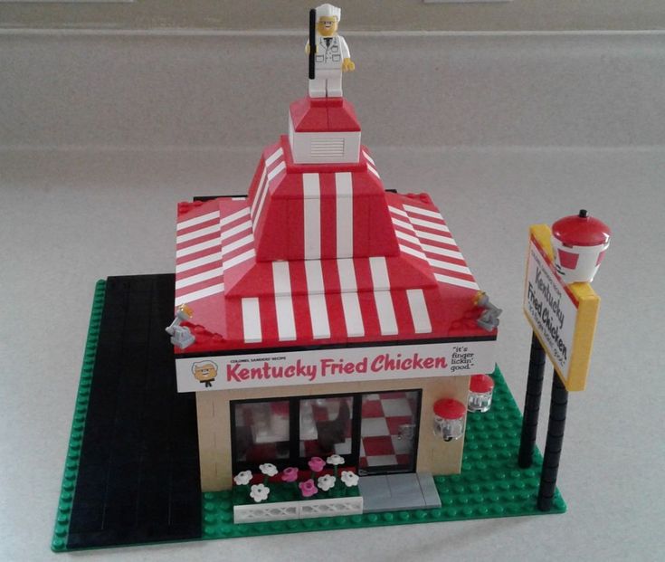 a lego model of a red and white striped building with a sign that says kentucky fried chicken