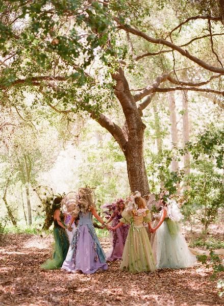 a group of women standing next to each other near a tree