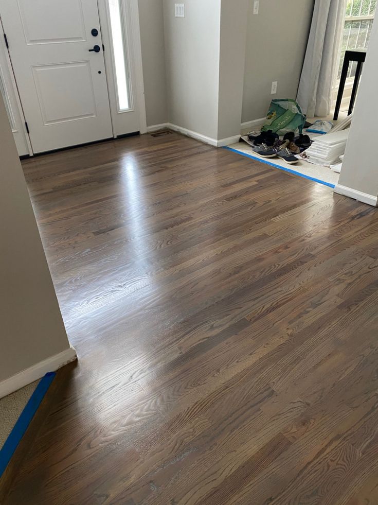 an empty room with hard wood flooring in the process of being painted and installed