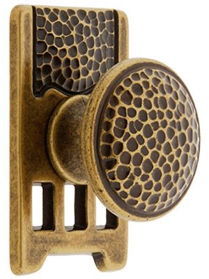 an antique brass door knob with holes in the front and back side, on a white background