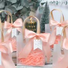 small bags with pink ribbons and tags on them