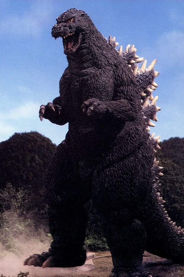 a large godzilla statue standing on top of a rock