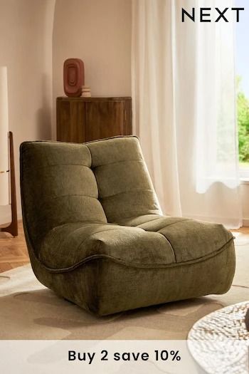 a green chair sitting on top of a rug next to a window