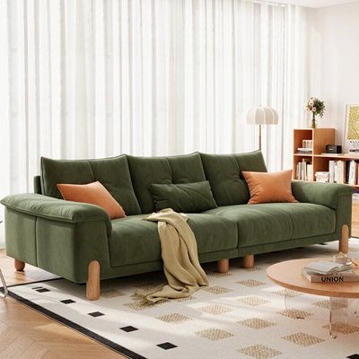 a living room with a green couch and coffee table