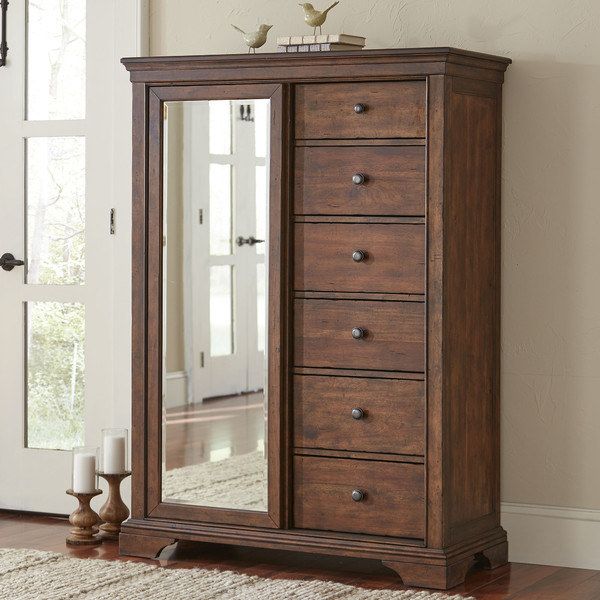 a large wooden dresser sitting in front of a mirror on top of a hard wood floor