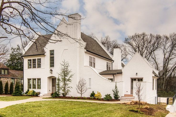 a large white house sitting on top of a lush green field