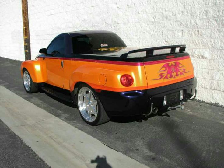 an orange and black car parked in front of a building