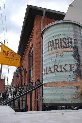 an old barrel sitting on the side of a building next to a fence and snow