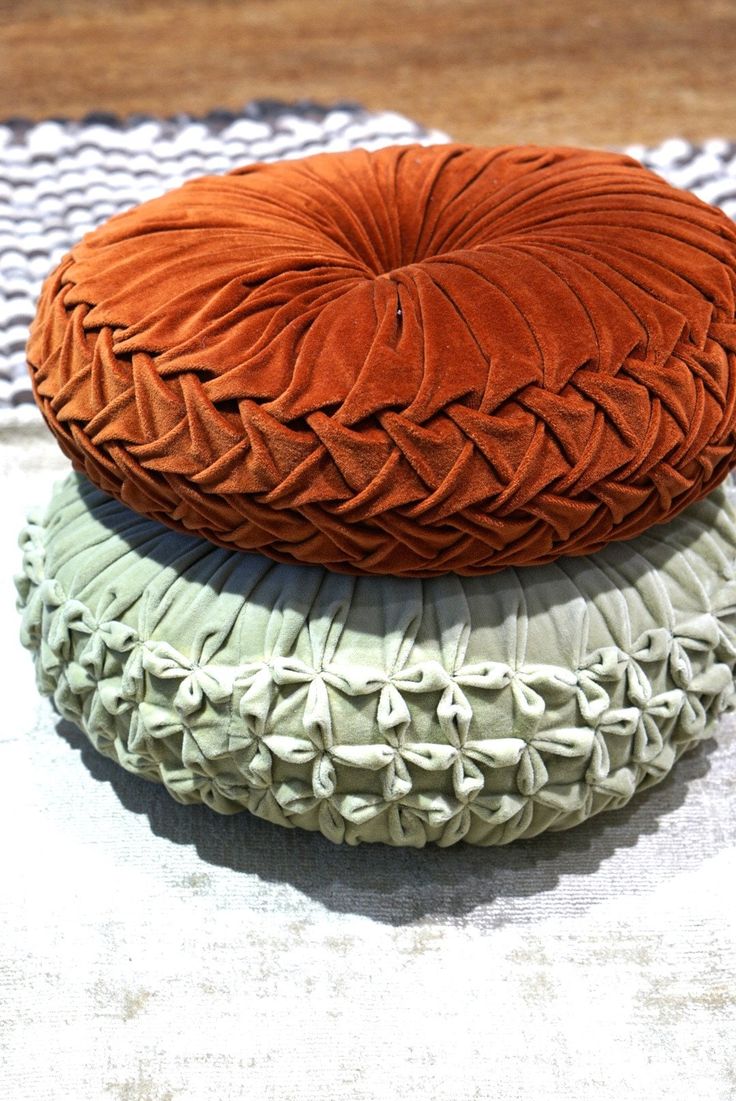 three round cushions are stacked on top of each other, one is orange and the other is green