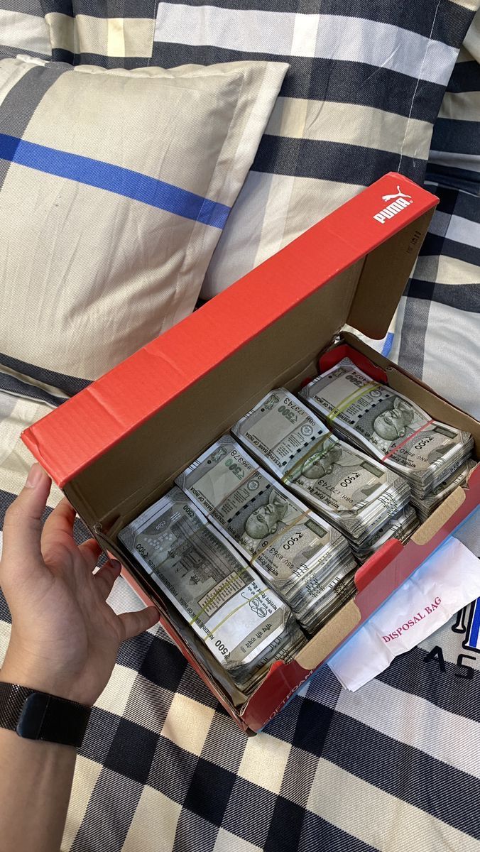 a person is holding a box full of money