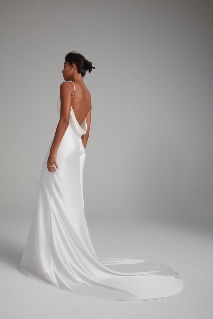 a woman in a white wedding dress with her back to the camera