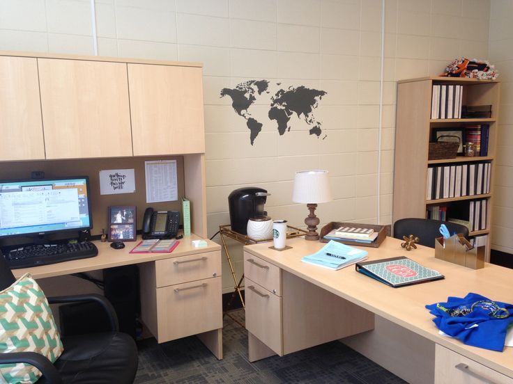 an office cubicle with desk, computer and bookshelf on the wall behind it