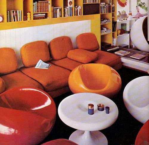 a living room filled with lots of furniture and bookshelves covered in yellow bookcases