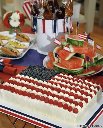 an american flag cake with watermelon and blueberries on the top is sitting on a table