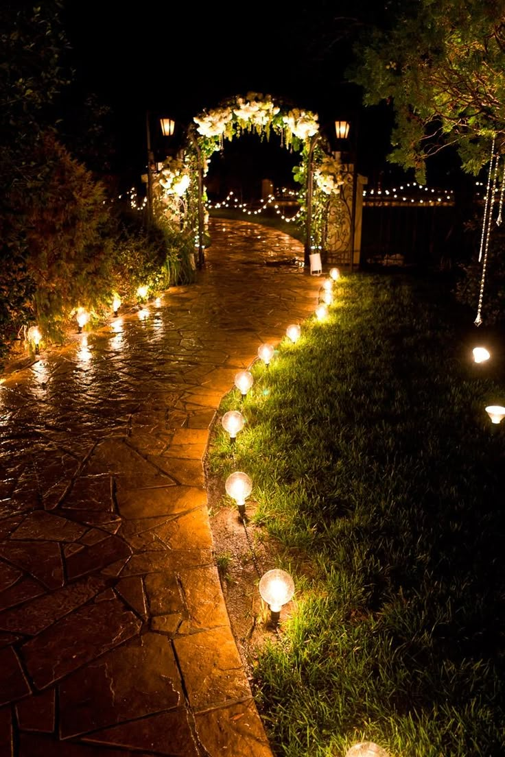 an outdoor path lit up with lanterns and string lights