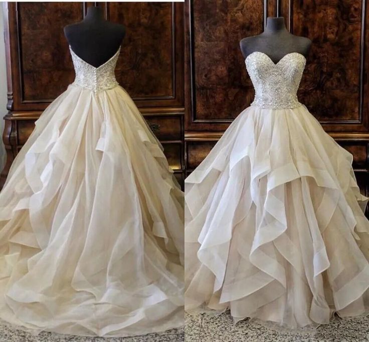 two wedding gowns on mannequins in front of wooden wall and floor