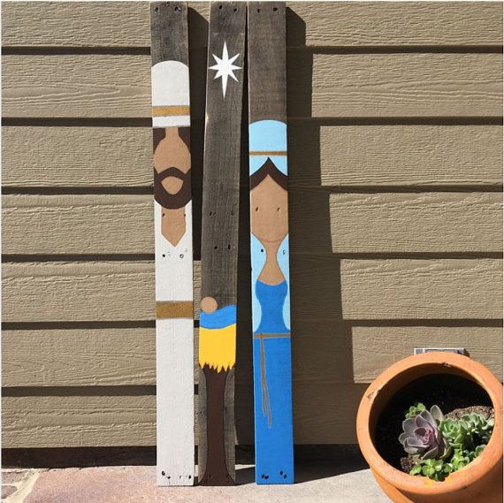 two wooden skis sitting next to a potted plant on the side of a house