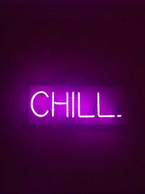 a neon sign that says chill on the side of a dark wall in a room