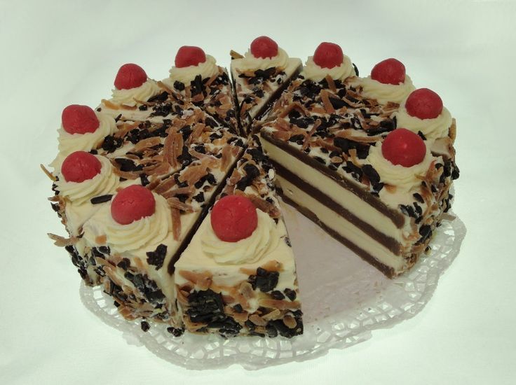 a cake with white frosting and chocolate shavings, topped with cherries