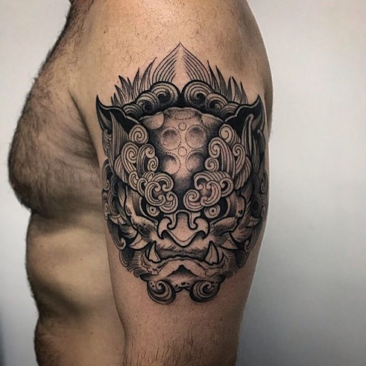 a man's arm with a tattoo on it that has an animal in the center