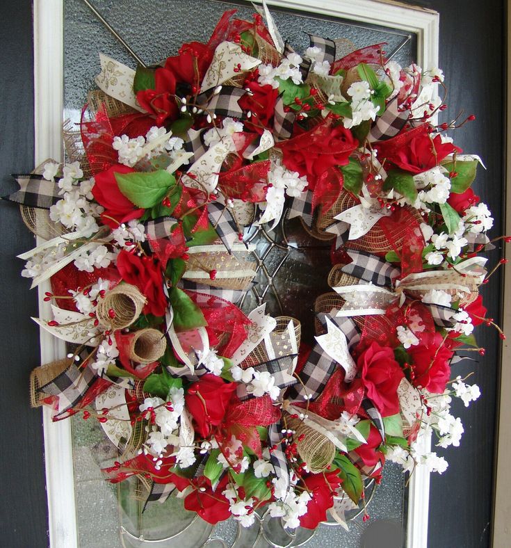 a red and white wreath on the front door